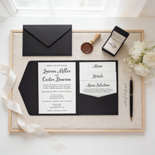 A wedding invitation featuring the names Lauren Miller and Carter Dawson, along with details of their wedding ceremony and reception. The invitation is accompanied by a menu selection, a wax seal, and a ring box. The scene is set on a wooden surface, with a bouquet of white flowers and a pen nearby.