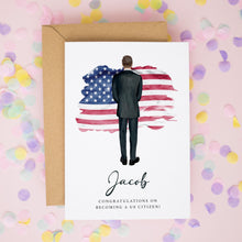 A greeting card with an illustration of a man standing in front of an American flag, surrounded by confetti. The card has a personalized message for a young man named Jacob, congratulating him on becoming a US citizen.