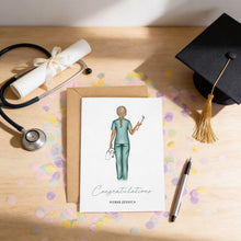 a graduation cap, a stethoscope, a greeting card with a nurse illustration, and confetti on a wooden surface.