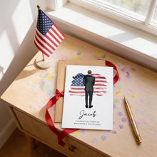 a greeting card with an American flag design, a pen, and confetti on a wooden surface.