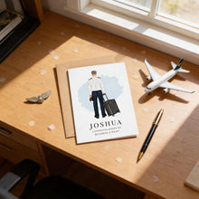 a greeting card with a man holding a suitcase, a model airplane, and a pen on a desk.