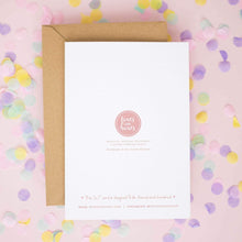 a white card with text and a logo, surrounded by colorful confetti on a pink background.