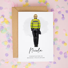 A greeting card featuring a police officer in a yellow uniform, with the name "Nicola" written below the image.