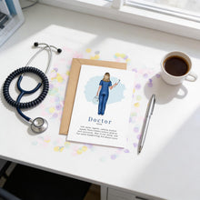 a card with a drawing of a woman in blue scrubs, a stethoscope, a pen, a coffee cup, and a medical book on a desk.