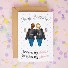 A birthday card with two women wearing black tops and holding drinks, surrounded by confetti. The card has a message that reads "Happy Birthday! Sisters by chance. Besties by choice."
