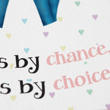 a close-up view of a white background with the phrase "by chance choice" written in black text. The background is decorated with small heart shapes in various colors, creating a colorful and playful atmosphere.