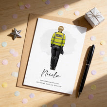 a card with a police officer illustration, a gift box, and confetti on a wooden surface.