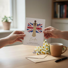 A person is holding up a card with a picture of a woman and the name 'Erina' on it, while another person is sitting at a table with a cup of coffee and a bouquet of flowers.