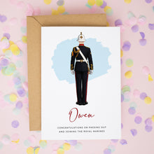 A greeting card with an illustration of a person in a military uniform, along with the name 'Owen' written on it. The card is placed on a background of confetti.