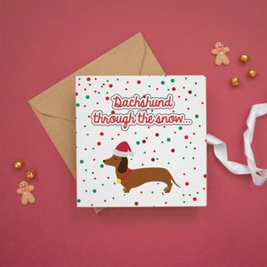 a card with a dachshund through the snow on it