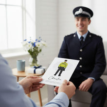 A person in a police uniform is sitting in a chair, while another person holds up a card featuring an illustration of a police officer.
