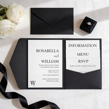 a black wedding invitation card with white text and a black envelope, along with a ring box and a rose arrangement.